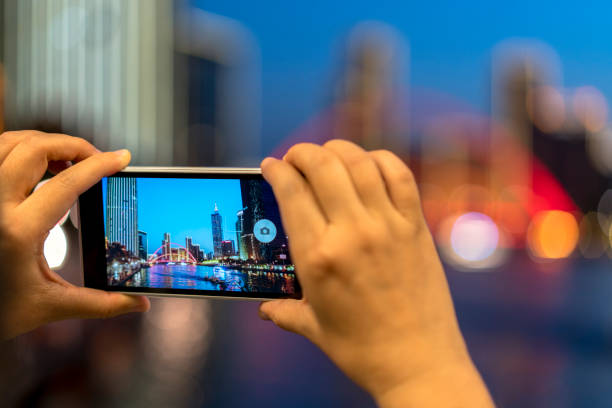istock using mobile phone taking pictures of cityscape at night 679275978
