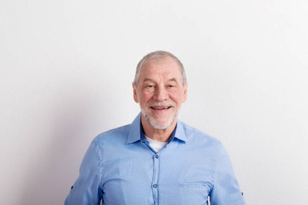 istock Senior man in light blue shirt smiling, arms on hips, studio shot. 679281156
