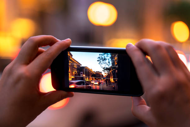 istock using mobile phone taking pictures of cityscape at night 679294516