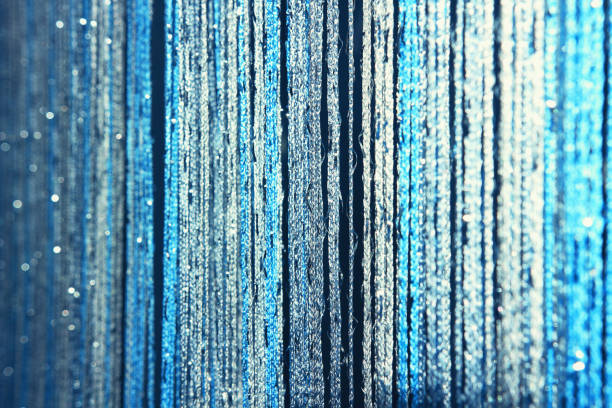 Elegant shiny blue glitter bow on blue colored ribbon and on blue burlap. Horizontal greeting card background with large copy space and decorated corner. Image toned in shades of blue.