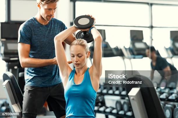 Woman Lifting Dumbbells Stock Photo - Download Image Now - Fitness Instructor, Health Club, Gym