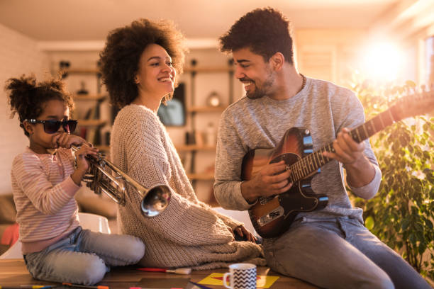 istock Playful black family having fun while playing musical instruments at home. 679305898