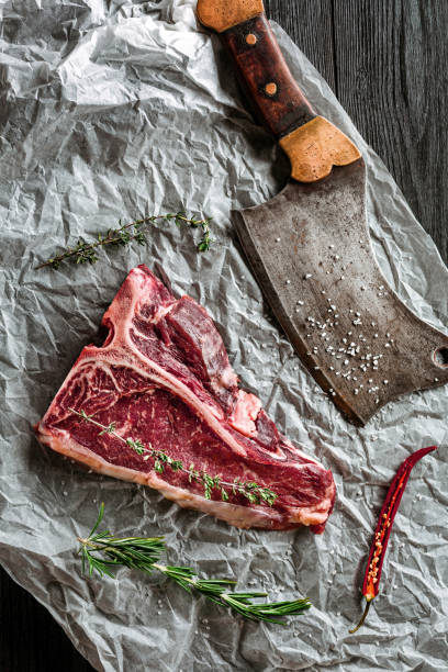 istock Raw dry aged t-bone steaks for grill with fresh herbs and cleaver 679306816