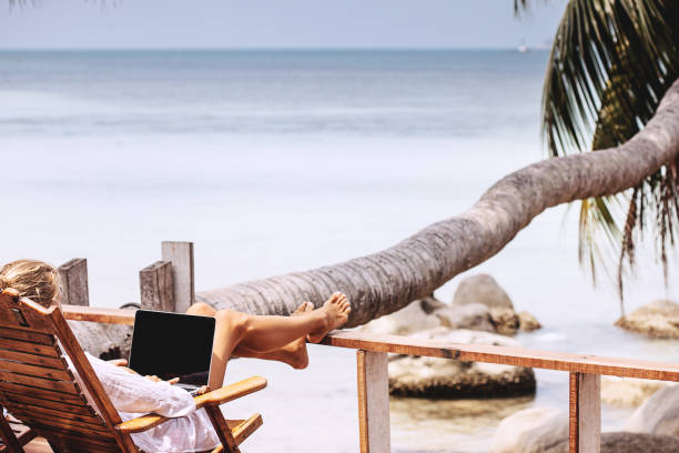 ビーチで働く若い女性 - on beach laptop working ストックフォトと画像