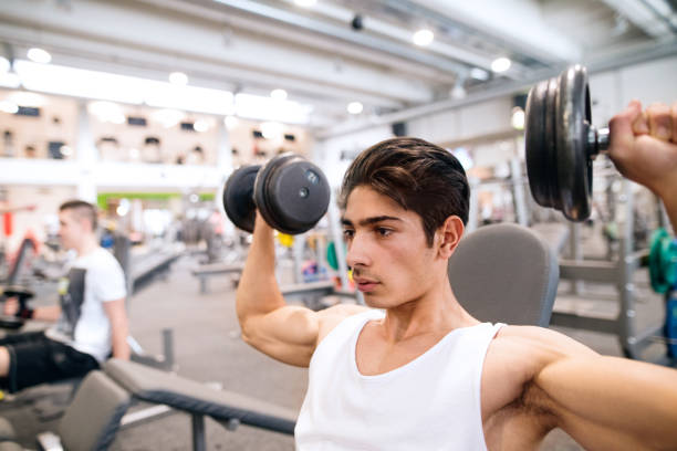 istock Hispanic man in gym on bench, working out with weights 679340328