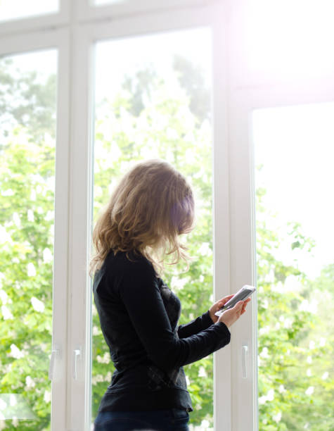 istock Blond woman holding modern smart phone with blank screen and copy space 679358904