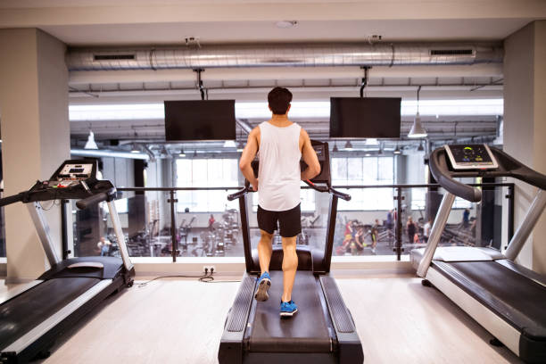 istock Young fit hispanic man in gym running on treadmill. 679359950