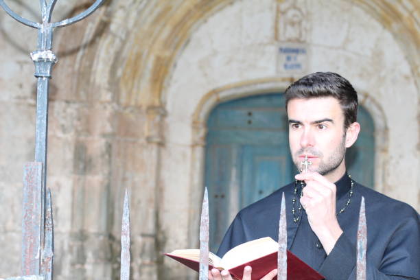 istock Priest kissing rosary while reading the bible 679405852
