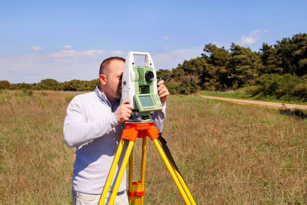 Man using of total station. Guy surveyor at work. Survey Instrument geodetic device, total station set and surveyor worker making measurement in the field. Total station outdoor at construction site. el hombre uso de estación total. topógrafo de chico en el trabajo. encuesta instrumento geodésico dispositivo, estación total set y topógrafo trabajador hacer la medición en el campo. total de la estación al aire libre en el sitio de construcción.