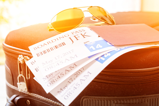Airline boarding pass tickets with passport and sunglasses on a luggage