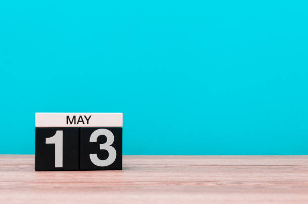 istock May 13th. Day 13 of month, calendar on turquoise background. Spring time, empty space for text 679449130