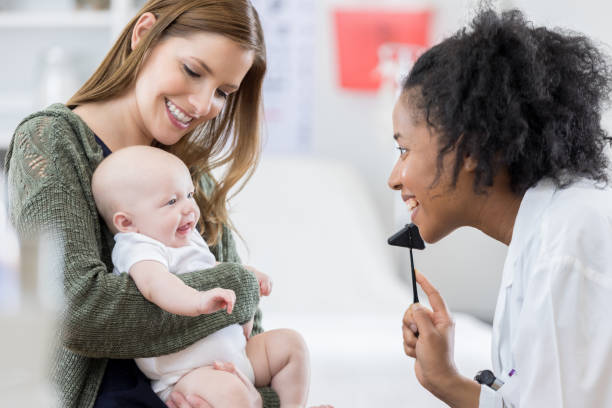 istock Cheerful pediatrician checks young patient's reflexes 679454072