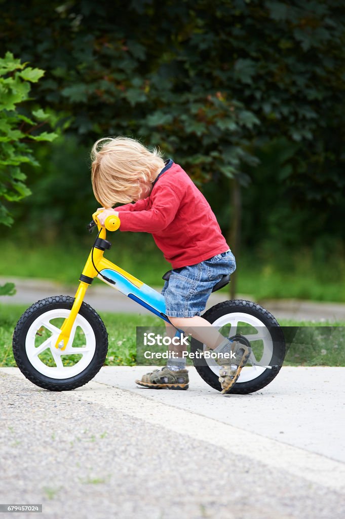 Onnellinen taapero lapsi poika ajaa pyörällä. Lapset nauttivat pyöräretkestä. - Rojaltivapaa avainsanalla Activity ja tyyppiä Kuvapankin valokuva