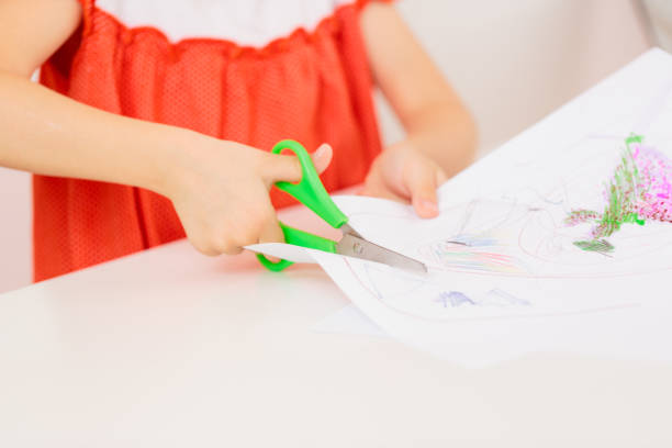 istock Child's hands cutting paper with scissors 679460174
