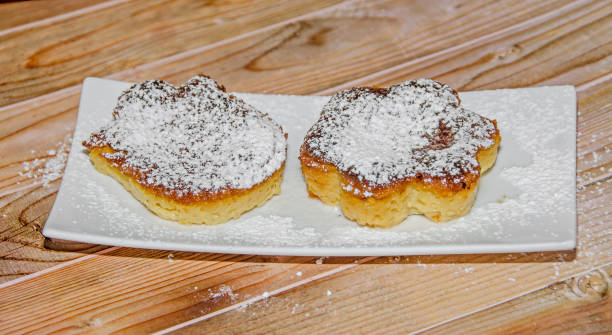 homemade creme brulee with powder sugar,  burnt cream, crema catalana, or trinity cream, white plate and wood background - custard creme brulee french cuisine crema catalana imagens e fotografias de stock