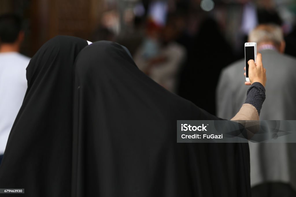 Muslim women with black hijabs posing for a selfie in a mosque in Qom, Iran Adult Stock Photo