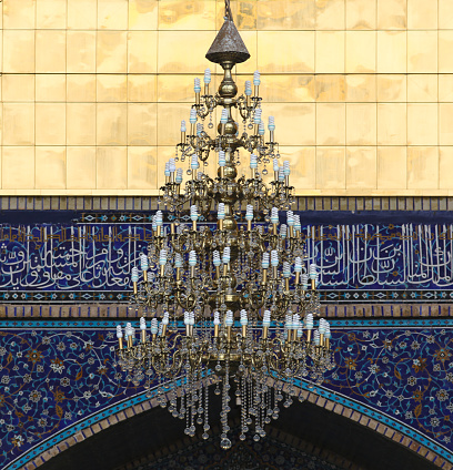 Big golden crystal lamp with ecologic bulbs in the entrance to Qom Mosque
