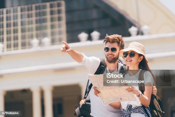 Multiethnic Traveler Couple Using Generic Local Map Together On Sunny Day Man Pointing Toward Copy Space Honeymoon Trip Backpacker Tourist Asia Tourism Or Holiday Vacation Travel Concept Stock Photo - Download Image Now