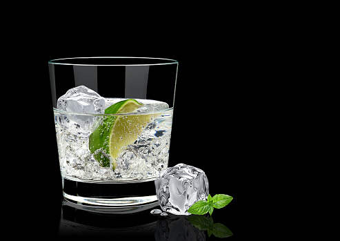 Gin tonic, lime and basil isolated on black background