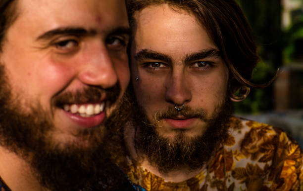 Face portrait of a young gay couple, photographed with natural light of the late afternoon. Selective focus. Face portrait of a young gay couple, photographed with natural light of the late afternoon. Selective focus. casamento stock pictures, royalty-free photos & images