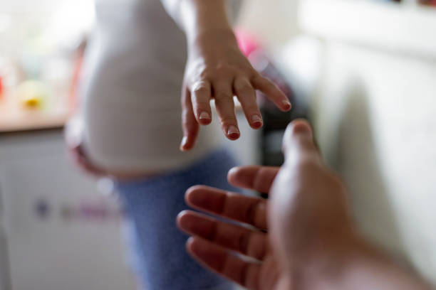 Help or support concept, Man and pregnant woman reaching each other hand at home, Expecting couple, Parents to be , Enjoying the pregnancy together, Young couple expecting a new baby