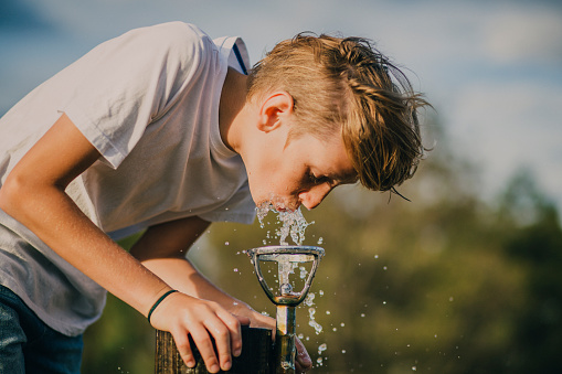 Young Boy Drinking from a Water Fountain