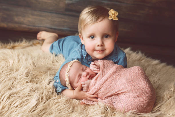 dwuletnie i nowo narodzone siostry razem - fake fur white happiness beginnings zdjęcia i obrazy z banku zdjęć