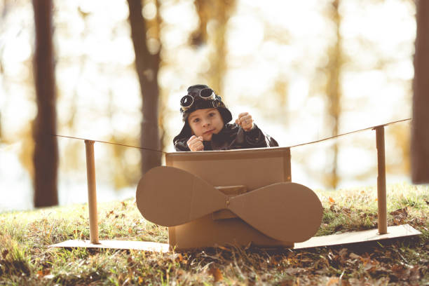 istock front view vintage pilot boy flight by imagination on cardboard plane outdoor 679513196