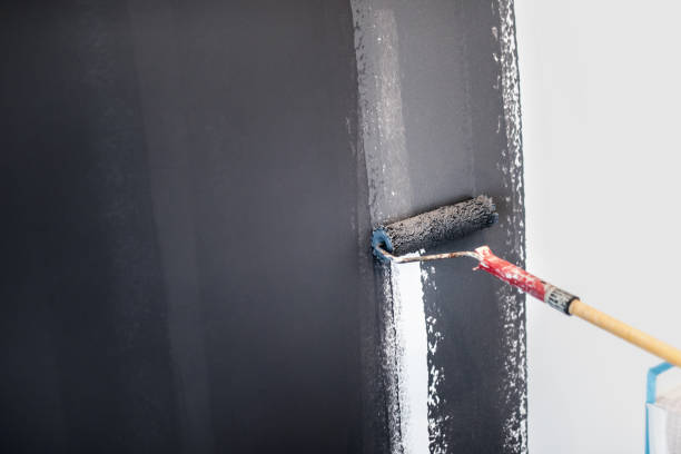 istock construction worker painting gray walls using paint roller. Details of interior design, renovation and plastering walls 679521546