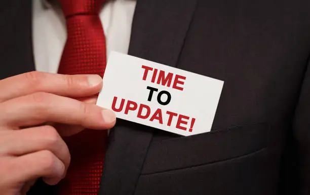 Photo of Businessman putting a card with text Time to upgrade in the pocket