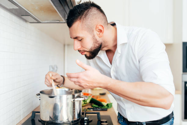 istock Modern lifestyle with man cooking soup and preparing dinner. Master chef preparing food 679524332