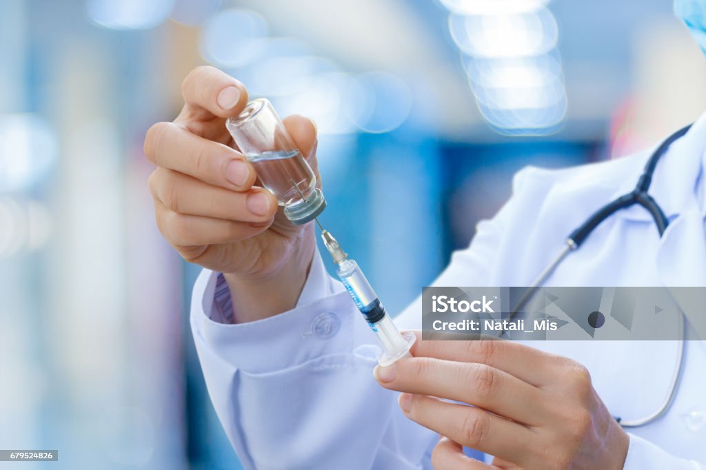 El doctor prepara la jeringa para la vacunación. - Foto de stock de Vacunación libre de derechos