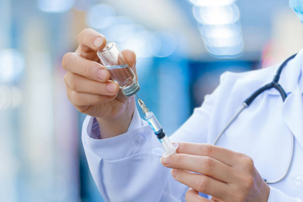 the doctor prepares the syringe for vaccination. - injetar imagens e fotografias de stock