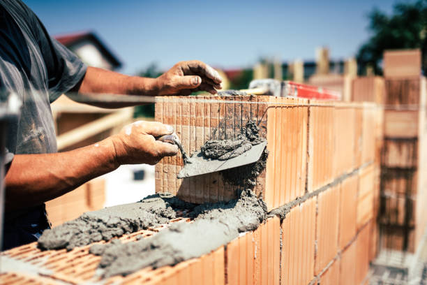 istock Industrial construction worker using spatula and trowel for building walls with bricks and mortar 679524872