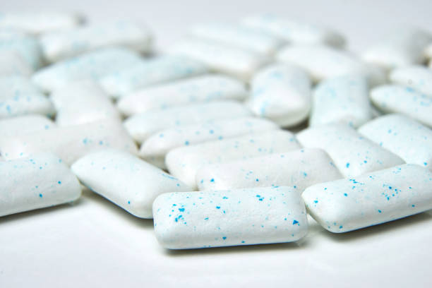 Chewing gum spilled out on white background with low depth of field - macro shot. Chewing gum spilled out on white background with low depth of field - macro shot mint chewing gum stock pictures, royalty-free photos & images