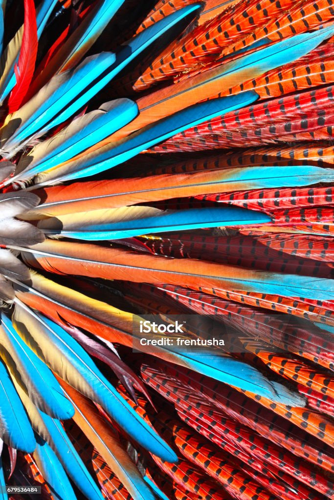 Multi-colored feathers in native american indian chief headdress Multi-colored feathers in native american indian chief headdress. Close-up photo Indigenous North American Culture Stock Photo