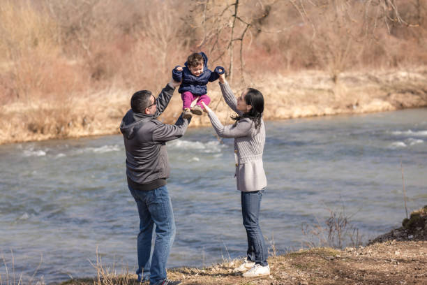 istock Young couple playing with baby daughter on riverside 679536658
