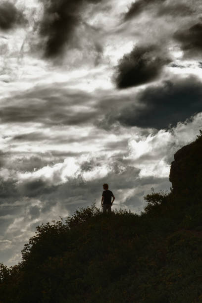 istock Teenage boy hiking on hilltop with dramatic sky 679538298