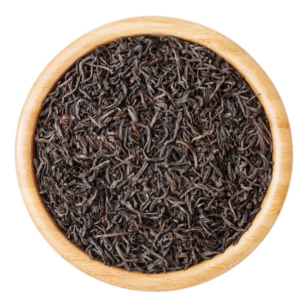 istock Black tea in wooden bowl isolated on white background with clipping path 679558704