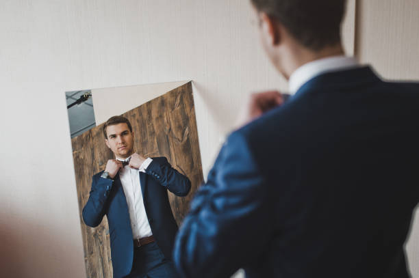 istock A man appreciates his outfit in the mirror 6414. 679559362