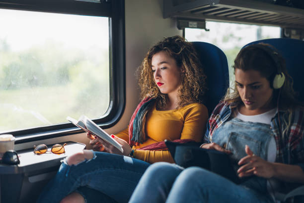 istock Two bored women reading in train. 679563046