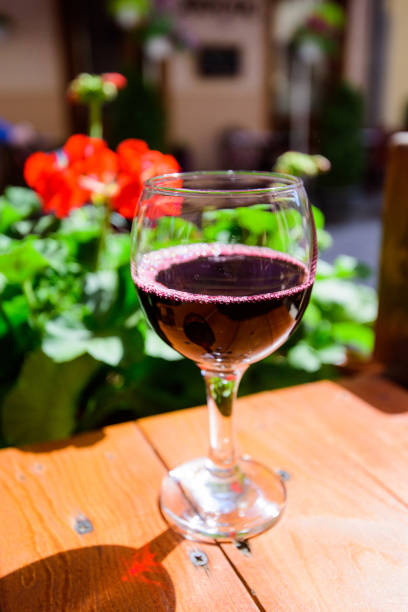 a glass of red wine on the vibrant restaurant background. selective focus. - bentham imagens e fotografias de stock