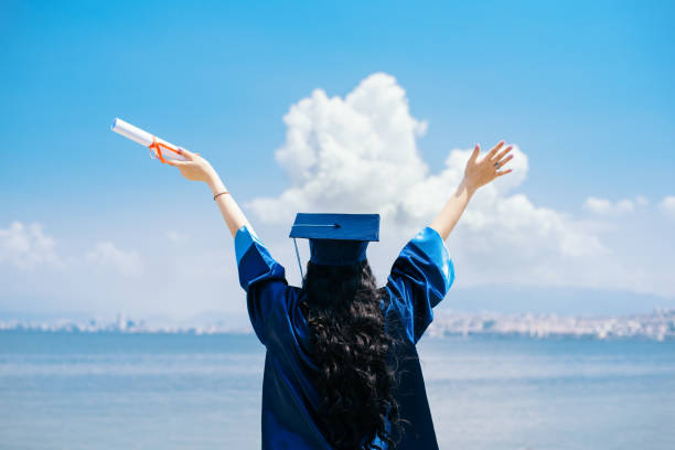 Female graduate student with arms raised