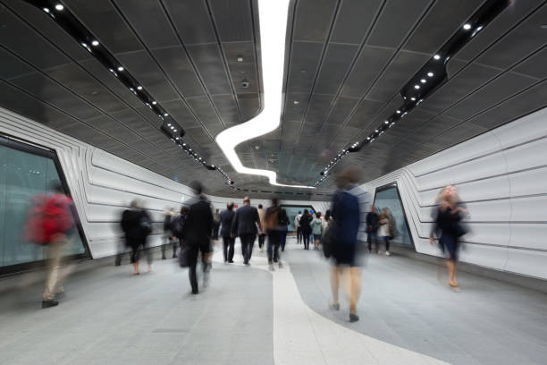 lavoratori aziendali del centro città che camminano attraverso un tunnel futuristico - defocused crowd blurred motion business foto e immagini stock