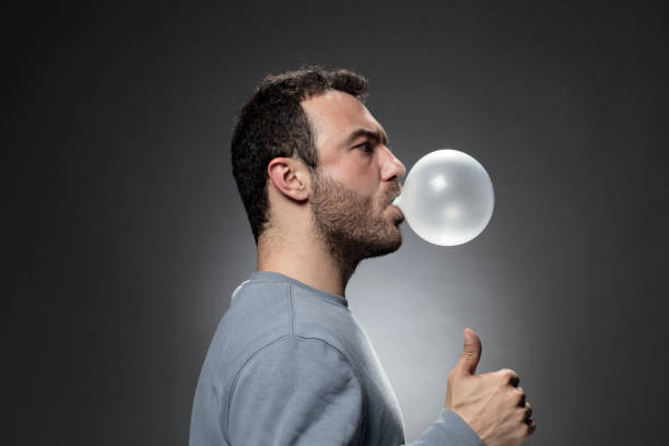istock Young Man chewing a gum and blowing bubble 679643518