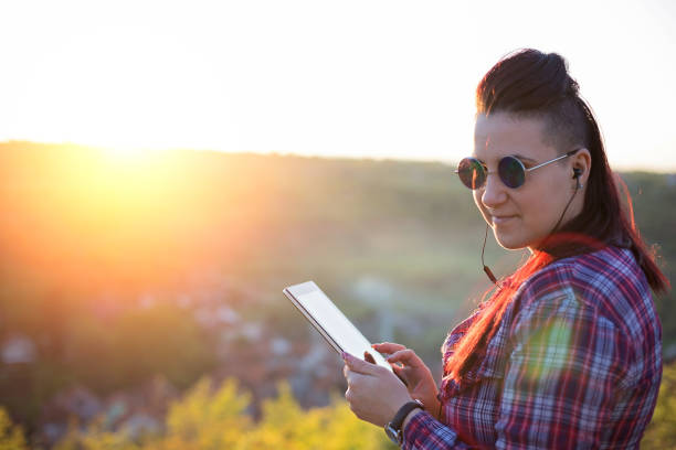 istock Young woman using digital tablet outdoors 679649564