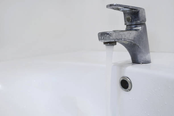 istock Closeup water flows from the tap in the bathroom 679654086
