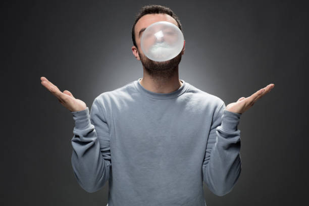 istock Young Man chewing a gum and blowing bubble 679657968