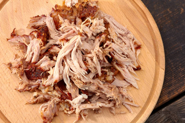 Pulled pork on round wooden board Pulled pork on rowmn wooden board. Top view barbecue pork stock pictures, royalty-free photos & images