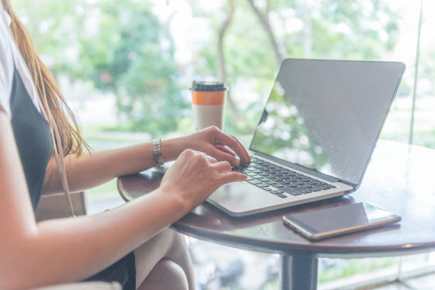 istock Female hand using laptop with coffee and smartphone beside 679672566